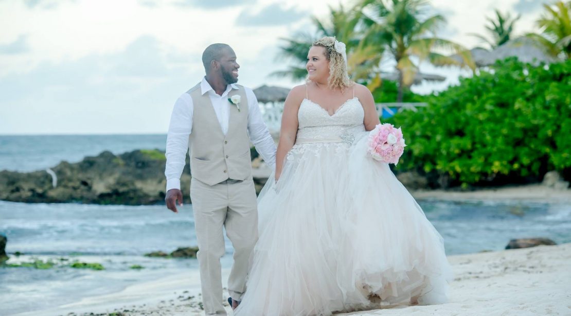 Bride and groom walking on the beach somewhere tropical