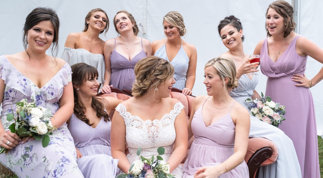Happy brid with bridesmaids in light purple dresses